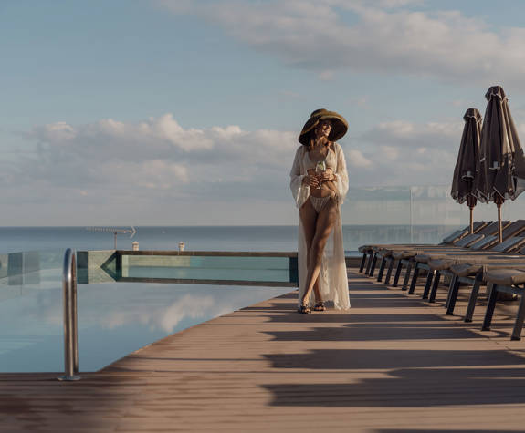 Α Woman Enjoying and her Drink Walking By The Pool