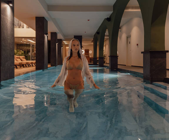 A Woman Walking in the Interior Pool