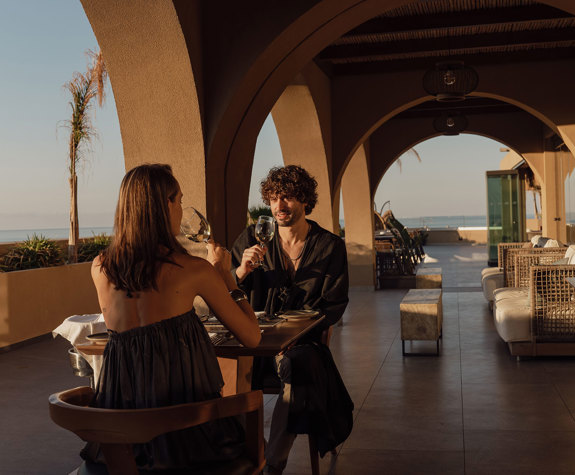 Minos Ambassador Elia Restaurant Couple Enjoying Their Wine as Sun Sets