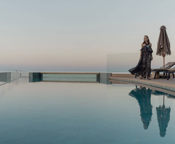 A Woman Walking in the Sunset by the Pool