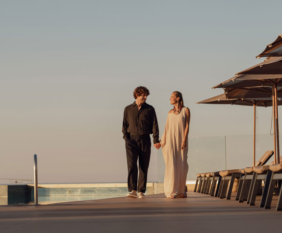 A Couple Walking By the Pool at Sunset
