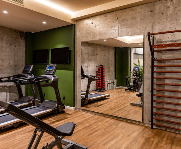 The Mirrors Of the Gym Next to the Treadmills and More Equipment