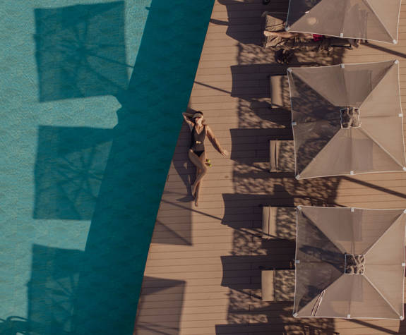 A Woman Sunbathing on the Side of the Pool Aerial View