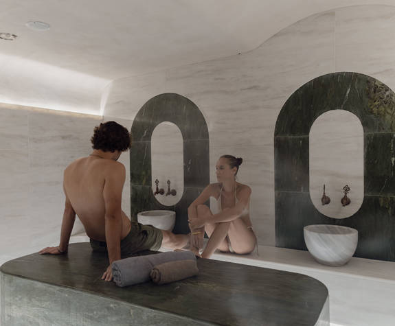 A Couple Sitting on the Marble Spa Table in the Spa Room