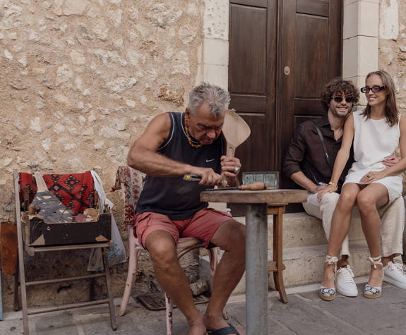 Couple Enjoying Watching A Traditional Instrument Maker Downtown